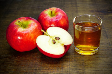 Apple cider vinegar in glass with apples on a wooden background.Selective focus.