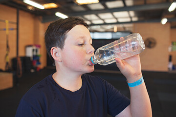 A male youth / child exercising at a crossfit style gym