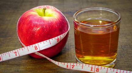 apple cider vinegar,apple and apple juice with tape measure on white background, healty food, drink for weight control in summer.