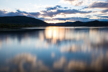 Coucher de soleil en longue exposition sur la Lac du Salagou par temps nuageux (Occitanie, France)