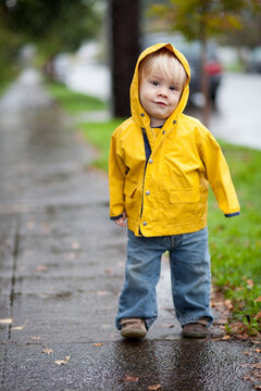 19-month-old boy in yellow rain jacket on a rainy day in Portland, Oregon