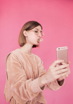 Beautiful young blonde female blowing bubble gum