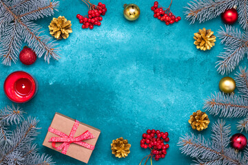 Christmas greeting card with blue fir branches and gold pine cones. Clusters of red viburnum berries, candle, shiny baubles and gift box. New Year background with holiday decorations. Seasonal mockup.