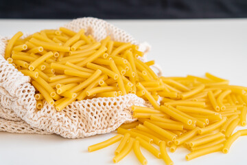 Raw dry uncooked Macaroni pasta spaghetti noodle on white bowl wooden background for basil tomato pesto sauce Homemade Italian food organic whole wheat vegan spaghetti for a healthy meal