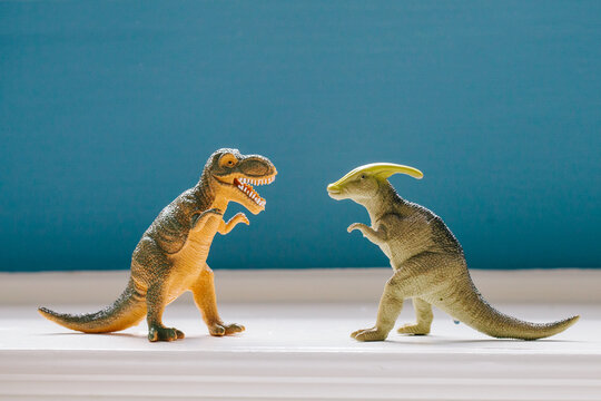 Fototapeta two dinosaurs facing off on a toy shelf