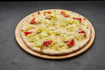 Delicious Italian pizza Caesar on dark background