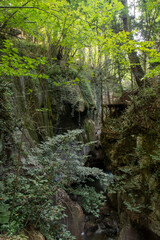 General front view of Samandere Waterfall plashing from high rocks surrounded by forest.