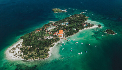 Aerial drone panoramic view of the paradise island with resort hotel, boats, palm trees, white sand beach and blue water of Atlantic Ocean, Cayo Levantado, Samana, Dominican Republic 