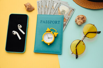 Outfit and accessories of traveler on yellow blue background. Overhead view of traveler's accessories