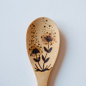 Wood burned bamboo wooden spoons on white background.