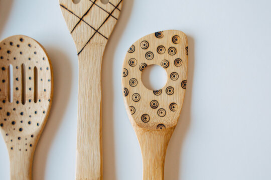 Wood burned bamboo wooden spoons on white background.