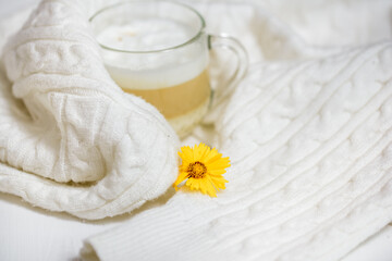Autumn or winter cozy composition. Cup of coffee, warm knitted White sweater. Flat lay, top view