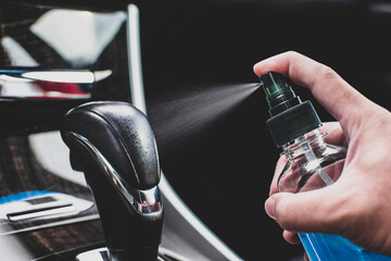 Cleaning gear lever with alcohol sanitizing spray in a car for protection disease and antibacterial...