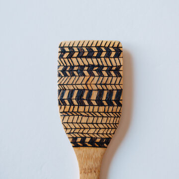 Wood burned bamboo wooden spoons on white background.