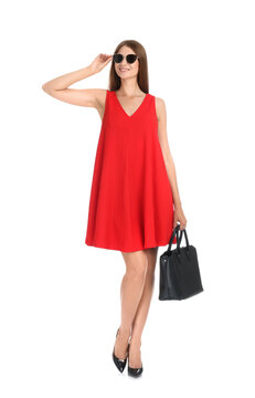 Young woman wearing stylish red dress with elegant bag on white background