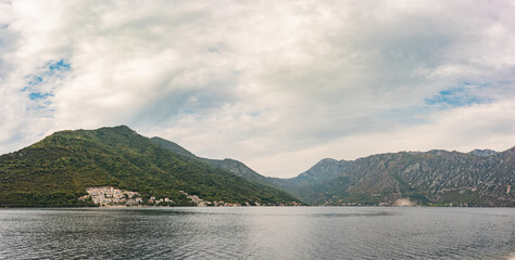 Panorama at the Kotor bay, near Perast, Montenegro. Small villages and massive mountains with stormy clouds