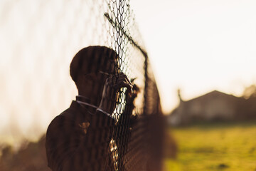 African man behind an iron grid