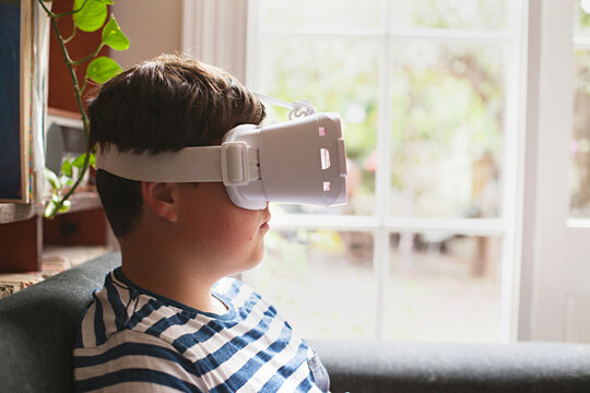 A young boy using virtual reality googles / headset at home