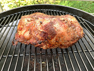 A large piece of roast pork on the grill