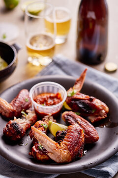 Cooked chicken wings on a plate with a sauce.