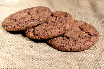 Three Shekoladno oatmeal cookies on sackcloth concept homemade baking close up