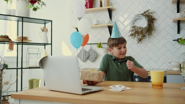 Birthday party. Joyful todder boy showing laptop screen to shocked parents walking away. Teenager congratulating birthday wishes online remote communications.