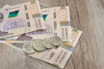 Ukrainian banknotes and coins on a wooden background. Financial concept. 500 hryvnia