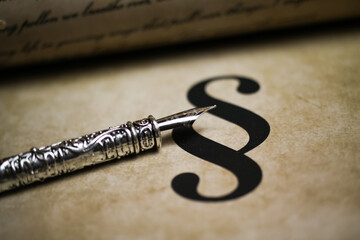 Closeup of isolated paragraph sign on ol vintage paper with silver retro ink pen and text document...