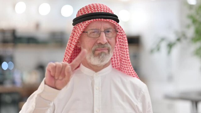 Old Arab Businessman saying No by Finger Sign