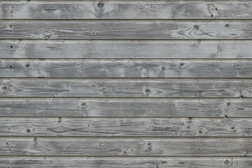 Obraz premium Gray wall of a wooden house. The wood texture is visible on the boards. Background.