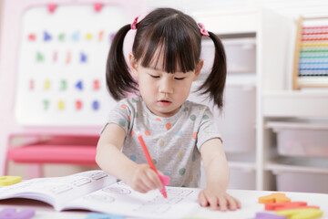 young  girl practice writing letters for homeschooling
