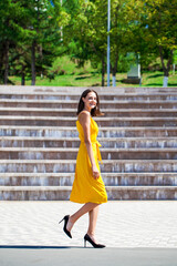 Young beautiful brunette woman in yellow dress