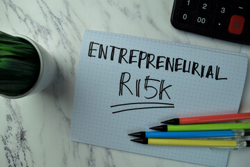 Entrepreneurial Risk write on a book isolated on office desk.