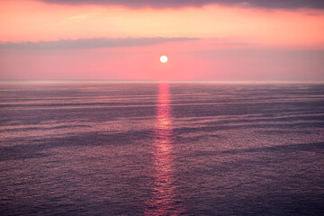 Romantic pink sunset with sunshine on the water surface. Spain, Andalucia, Nerja.