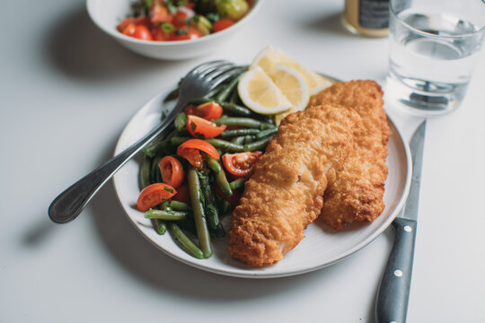 Breaded fish fillet with salad of green beans and tomatoes