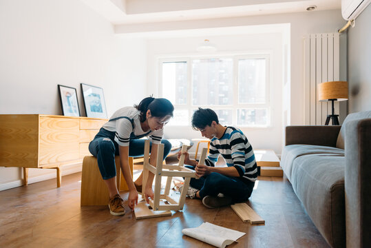 Young couple assembling flat-pack furniture
