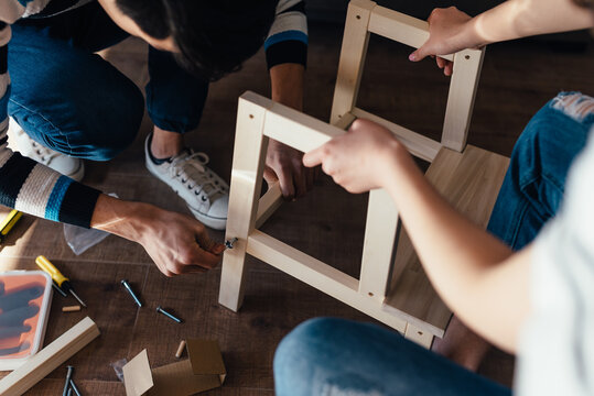 Young couple assembling flat-pack furniture