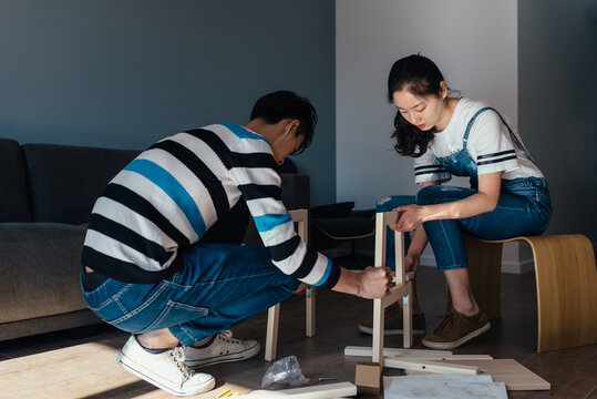 Young couple assembling flat-pack furniture