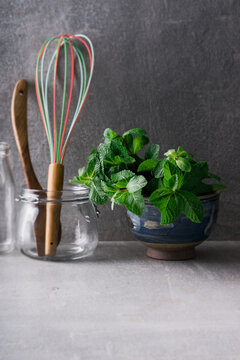 Fresh mint bundle in a bowl on kitchen work surface.