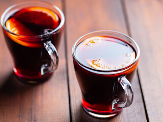Mulled wine on wooden background. Winter drink traditional for the Christmas holidays. Two glasses of Christmas mulled wine with oranges
