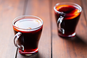 Mulled wine on wooden background. Winter drink traditional for the Christmas holidays. Two glasses of Christmas mulled wine with oranges