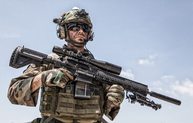Half-length portrait of special forces sniper or marksman, army soldier in camouflage uniform and...