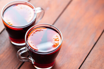 Mulled wine on wooden background. Winter drink traditional for the Christmas holidays. Two glasses of Christmas mulled wine with oranges