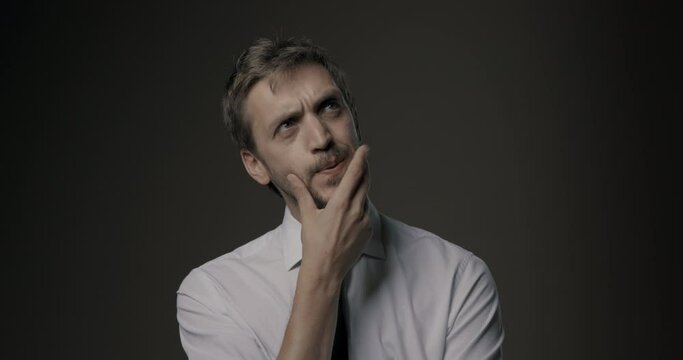 Pensive man thinking with hand on chin