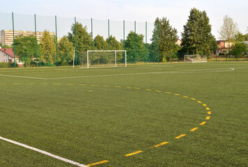 A view of a net on a vacant soccer pitch.
