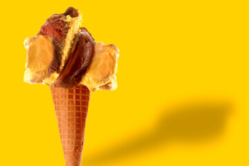 takeaway ice cream cone with chocolate, cream and vanilla flavor on yellow background