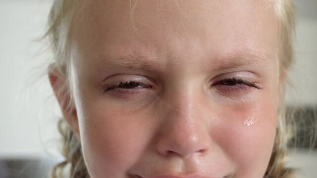 A little girl with white hair is crying. Upset and resentful child
