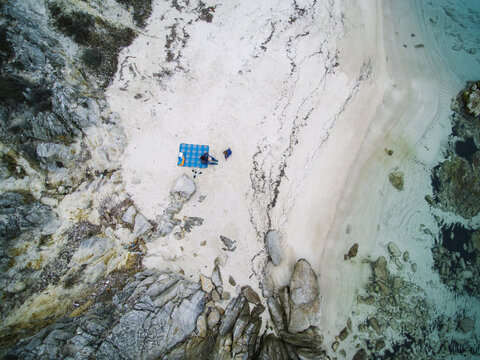 family having picnic on a beach from above - greece