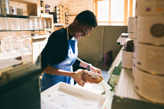 Portrait of a smiling female grocer in a local shop.