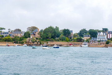 Fototapeta na wymiar Ile de Brehat, France - August 27, 2019: View of the Port-Clos ferry landing and coastal hotels on Ile de Brehat island in Cotes-d'Armor, Brittany